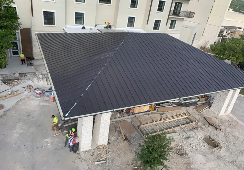 Metal roofing installation team working on a commercial building in Lexington